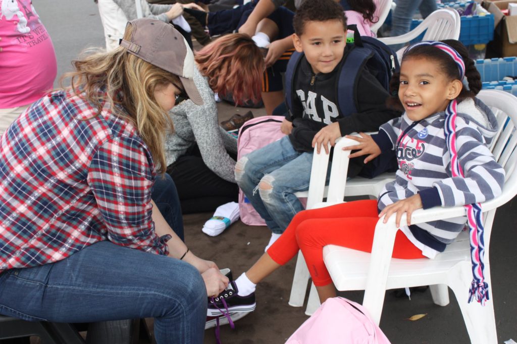 ypg-helping-kid-with-shoes